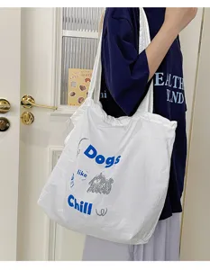 Detailed view of casual white canvas tote bag with blue graphic print, perfect daily style.