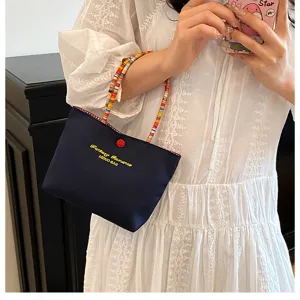 Sac à main décontracté élégant avec poignée en perles colorées et broderie pour l'été.