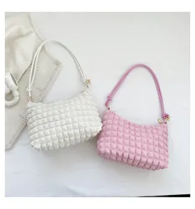 Detailed shot of stylish puckered grid shoulder bag, trendy cloud textured women underarm bag.