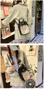 Detailed view of a black nylon Japanese itabag with a transparent front pocket worn by a model.