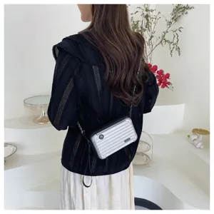 Mini suitcase crossbody bag for women, metallic silver hardshell travel box shoulder bag.