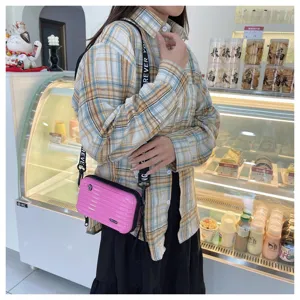 Stylish pink mini suitcase crossbody bag for women, cute hard shell shoulder bag with strap.