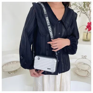 Mini suitcase crossbody bag for women, stylish hardshell shoulder bag with wide strap.
