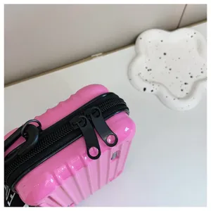 Detail view of pink mini suitcase crossbody bag with black zipper, perfect for daily fashion wear.