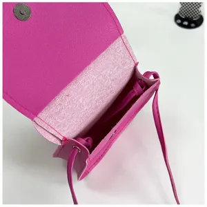 Pink mini crossbody bag detail, cute small shoulder bag with magnetic snap closure and slim strap.