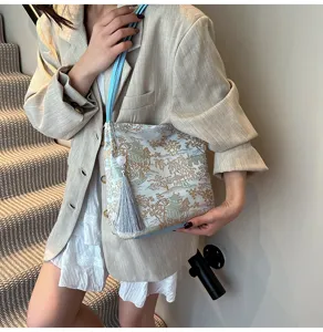 Chinese style embroidered shoulder bag detail, elegant landscape tote with tassel pendant.