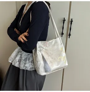 Detailed view of the new Chinese style satin shoulder bag with elegant bamboo and tassel charm.