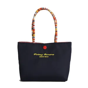 Sac à main fourre-tout en toile élégant avec poignées tressées et bouton pression.