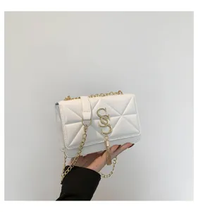 White quilted chain crossbody bag detail, featuring elegant gold hardware and chic tassel pendant.