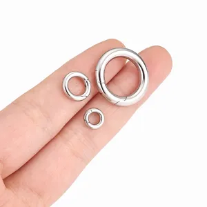 Close-up detail van zilveren roestvrijstalen veerringen in drie maten op de vinger voor knutselen.