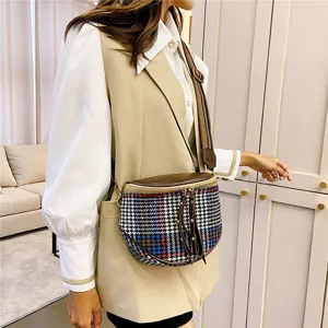 Detailed view of the stylish plaid crossbody bag with wide strap and tassel zipper pull.