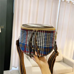 Detail view of houndstooth crossbody bag showing textured fabric, wide strap and dual zippers.