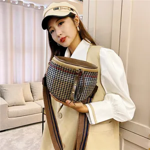 Detailed view of women houndstooth crossbody saddle bag with wide strap stylish casual accessory.