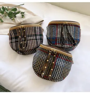Detail shot of stylish houndstooth plaid crossbody bags with leather tassel and metal stud accents.