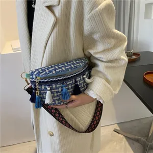 Detailansicht der blauen Tweed Umhängetasche mit Quasten und breitem gemusterten Gurt.