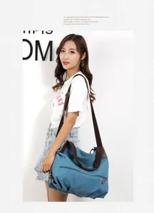 Detail shot of casual canvas shoulder bag with brown strap, side view showcasing daily use.