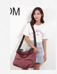 Detail view of women's casual wine red canvas crossbody shoulder bag with brown straps.