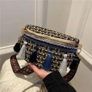 Detailansicht der gewebten Tweed-Brusttasche mit bunten Quasten und breitem Ethno-Gurt.