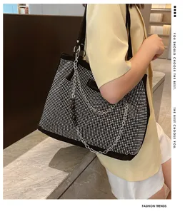 Gedetailleerd overzicht van een sprankelende strass tote tas met metalen ketting.