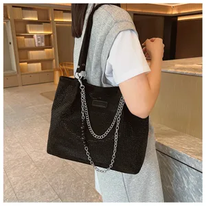 Gedetailleerd overzicht van een stijlvolle zwarte strass tote schoudertas met metalen ketting.