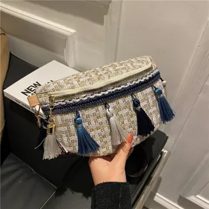 Detailaufnahme der gewebten Tweed-Brusttasche mit eleganten blauen Quasten und breitem Gurt.