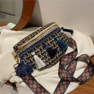 Nahaufnahme der gewebten Tweed Umhängetasche mit blauen Quasten und breitem Ethno-Gurt.