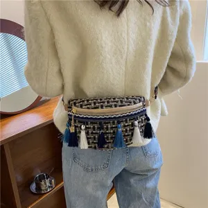 Detailansicht der stylischen gewebten Tweed-Umhängetasche für Damen mit bunten Quasten.