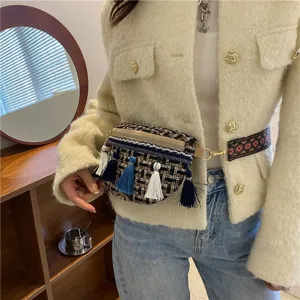 Nahaufnahme der stilvollen, gewebten Tweed-Brusttasche mit bunten Quasten und Ethno-Gurt.