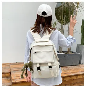 Casual large capacity school backpack with cute frog pendant, durable canvas book bag for daily use.