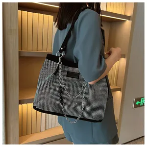 Gedetailleerd overzicht van modieuze strass schoudertas met metalen ketting accessoire.