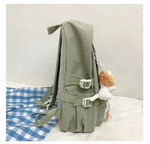 Mochila de lona para estudiante verde vista lateral, bolso escolar con hebillas.