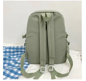 Detalle de mochila verde claro, bolsa escolar casual diaria, correas de hombro duraderas.