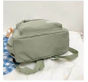 Vista detallada de una mochila escolar verde informal con correas ajustables y diseño de bolsillo.