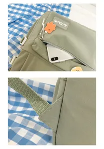 Vista detallada de la mochila escolar de lona verde claro con bolsillo delantero con cremallera.