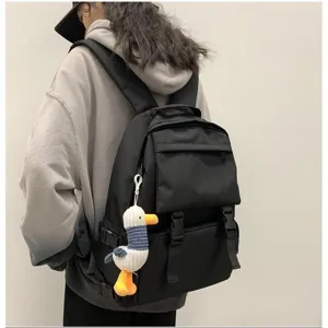 Detail view of the black canvas casual backpack with cute duck plush pendant and multi pockets.