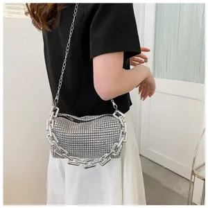 Sparkling rhinestone cylindrical crossbody bag detail with chunky silver chain decoration.