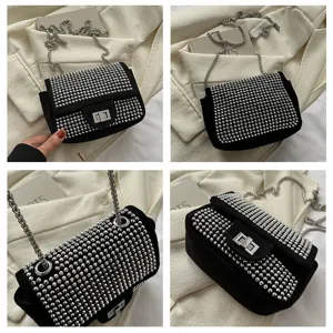 Detailed view of black rhinestone shoulder bag with silver chain strap and flap turn-lock closure.