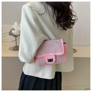 Detail view of a pink rhinestone shoulder bag, featuring sparkling crystals and chic chain strap.