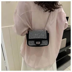 Chic black rhinestone shoulder bag detail showing sparkling crystals and metal chain.