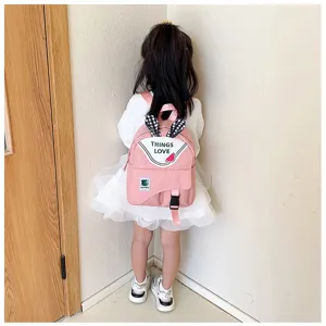 Cute pink children school backpack detail view with rabbit ears and flap pocket design for daily use.