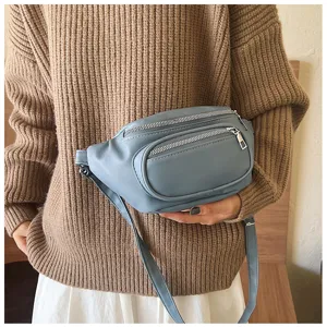 Detailed view of blue PU leather casual women waist bag with multi zipper pockets design.