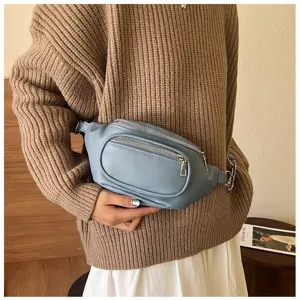 Light blue women waist bag detail view, casual PU leather sling bag with multi zippers.