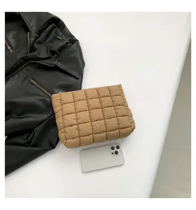 Quilted design khaki clutch bag detail shot, soft padded cosmetic bag, minimalist fashion accessory.