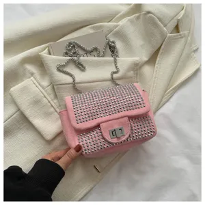 Detailed shot of pink rhinestone flap shoulder bag featuring a metallic chain and turn lock.