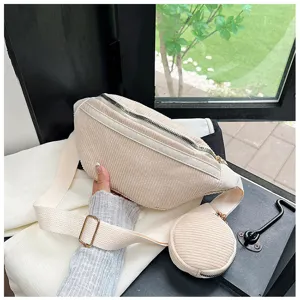 Vista detallada del elegante bolso de pecho beige de pana con un monedero redondo.