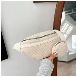 Detalle de riñonera de pana, bolso de cintura informal con monedero pequeño, textura beige.
