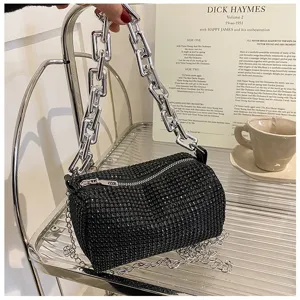 Black rhinestone cylindrical underarm bag detail, featuring chunky silver chain and sparkling crystals.