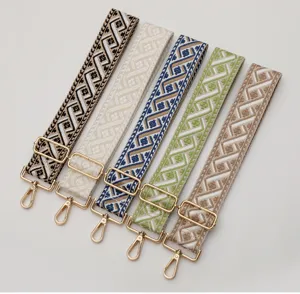 Adjustable wide woven bag strap replacement with ethnic geometric pattern and gold hardware.