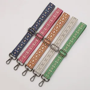 Ethnic woven bag strap with diamond pattern and adjustable metal hardware for shoulder bags.