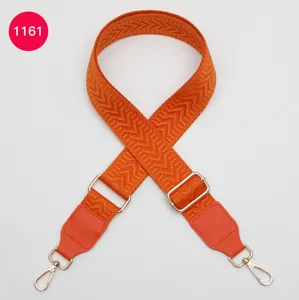 Replacement wide bag strap detail, orange chevron woven fabric with leather tabs and gold hardware.